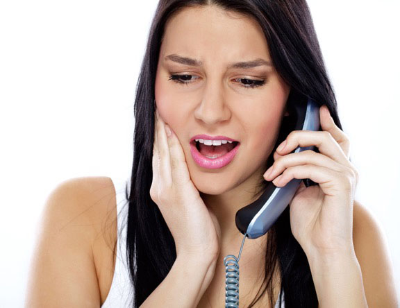 Woman with sore teeth on phone with dentist